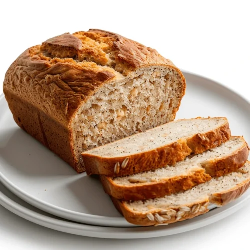 Freshly sliced spelt banana bread loaf arranged on a white plate with a clean, minimal background.